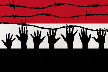 Yemen flag behind barbed wire fence. Group of people hands. Freedom and propaganda concept