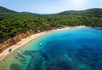 Naklejka na ściany i meble Mantraki beach with emerald sea and lush pine tree forrest at the island of Skiathos, Sporades, Greece