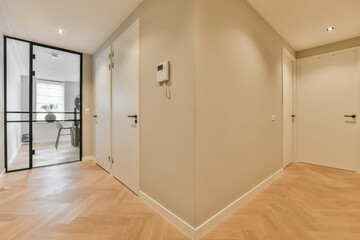 an empty room with wooden floors and white walls, there is a door leading to the left side of the room