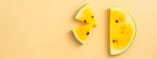 Sliced yellow watermelon pattern flat lay on pastel yellow table background.