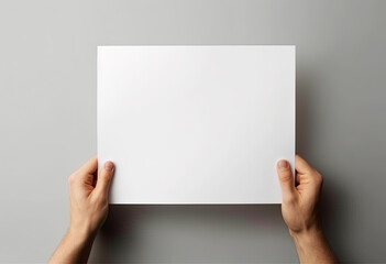 hands are holding a blank sheet of paper with a white background