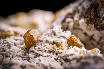 Vesuvianite crystal (known as idocrase too) on white matrix macro detail texture background. close-up raw rough unpolished semi-precious gemstone