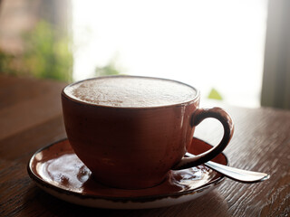 Cup of coffee on table in cafe infront of window. Closeup.