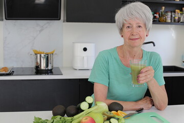 Senior woman preparing a green natural smoothie 