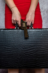 woman in red dress with gun and black suitcase isolated
