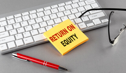 RETURN ON EQUITY text on a sticky with keyboard, pen glasses on grey background