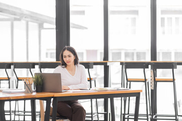 Young asian woman using laptop computer for business studying, watch online virtual webinar training meeting, video call. Focused asian woman or Latin business woman work in office, copy space. 