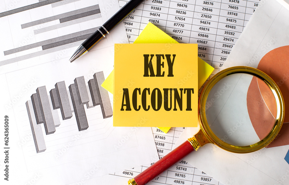 Poster key account text on a sticky on the graph background with pen and magnifier