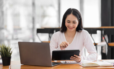 Fototapeta premium Young asian woman using laptop computer for business studying, watch online virtual webinar training meeting, video call. Focused asian woman or Latin business woman work in office, copy space. 