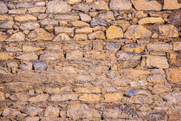 Stone antique old wall as a background or texture. Vintage background of a fortress wall in loft and grunge style with place for text and copy space.