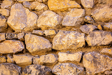 Stone antique old wall as a background or texture. Vintage background of a fortress wall in loft and grunge style with place for text and copy space.