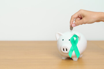 Fototapeta na wymiar September Ovarian cancer Awareness month, Teal Ribbon with Piggy Bank for support illness life. Health, Donation, Charity, Campaign, Money Saving, Fund and World cancer day concept