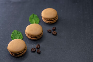 macaroons of different colors on a black background