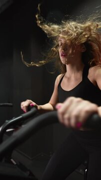 female running on elliptical orbitrek machine in fitness gym. Slow motion