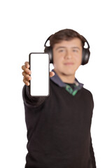 Caucasian boy with headphones out of focus shows the blank screen of his mobile phone isolated on a white background.