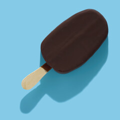 chocolate popsicle ice cream and hard shadow isolated on blue background, creative decoration of summer concept