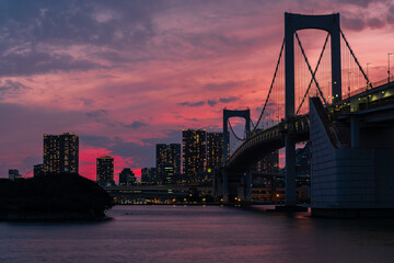 A purple dusk sky above the skyscrapers of Tokyo and Rainbow Bridge