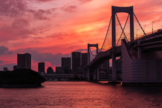 Beautifu firey sunset sky behing a suspension bridge and skyscrapers (Tokyo, Japan)