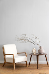 Fototapeta na wymiar Comfortable armchair close to coffee table with ceramic vases