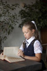 Primary schoolgirl, in school uniform, with a book