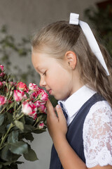 Primary schoolgirl, in school uniform, with a roses.