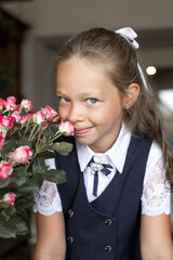Primary schoolgirl, in school uniform, with a roses.