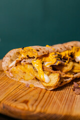 Panuozzo tradizionale napoletano con patate, provola filante, porchetta e cheddar poggiato su un...