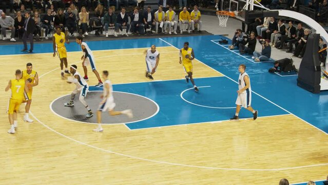 College Basketball Playoffs: Yellow Team Player Passing and Dribbling Past Rival Team, Talented Teammate Assists with a Powerful Alley-Oop Dunk Shot. Live TV and Intrernet Broadcast on Sports Channel