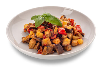 Traditional Italian vegetable caponata with basil leaves in white dish isolated