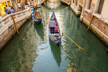 Fototapeta na wymiar Gondola ride in Venice (Venedik, Venetian). Traveling in a traditional gondola through narrow ancient canals. Italy