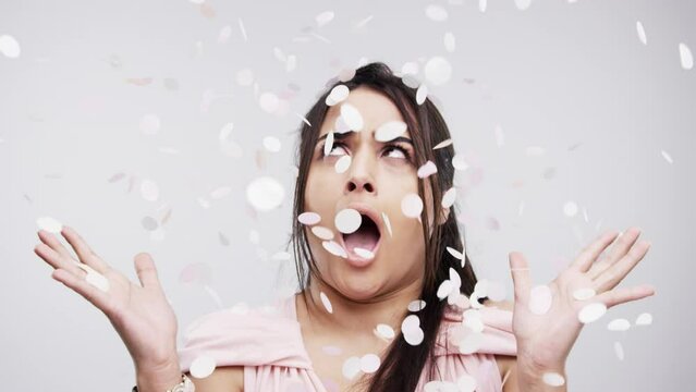 Surprise, confetti and wedding with a woman, bride or bridesmaid in studio on a gray background for marriage. Wow, love and celebration with a female shocked by falling flower petals as a newlywed