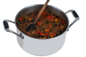 Faitout de ratatouille maison avec une cuillère en bois en gros plan sur fond blanc