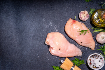 Raw chicken breast, white meat fillet steaks with greens, olive oil, spices, dinner cooking background top view copy space