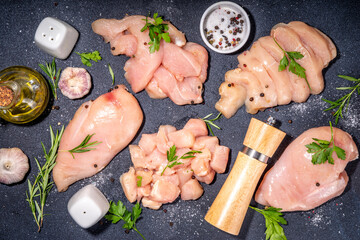 Chicken, turkey, white meat breast fillet on kitchen table, top view copy space. Different types of cutting meat. Strips, chopped, steak, cubes, whole breast, ready for cooking, with spices and herbs