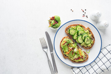 Avocado toast with cucumber, carrot and beet slices. Healthy vegan raw bread toast, top view, copy...