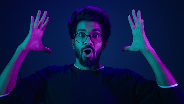 Male portrait neon ultraviolet background Arabian man Indian guy coder hacker showing head mind explosion gesture boom brainstorm idea mental shock information think computer technology sci-fi future