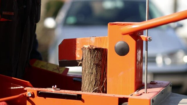 Hydraulic wood splitter cutting wood on a sunny day. 4K Video