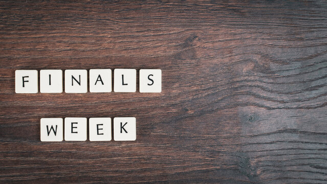 Back to school concept. Finals week word on wooden desk.