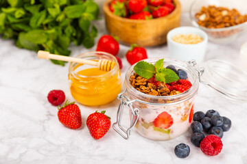 Granola bowl with yogurt and fresh almonds, blueberries, raspberries,peach and strawberries on a marble kitchen table.Acai and spirulina bowl.Healthy breakfast concept.copy space.Place for text.