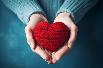 elderly female hands holding a knitted red heart made of threads.ai generative - obrazy, fototapety, plakaty