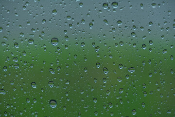 Lots of raindrops on the window. Rainy season concept. Climate change. Wet in rain. Focus on water droplets on window.