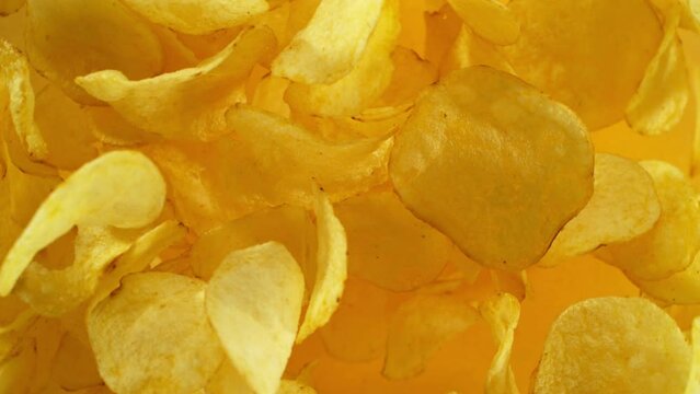 Super slow motion of flying fried potatoes chips on color gradient background. Filmed on high speed cinema camera, 1000 fps. Camera placed on high speed cine bot, tracking the target.