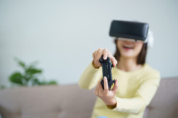 Young Asian woman gamer wearing virtual reality touching air during the VR experience  Future home technology player hobby playful enjoyment concept.