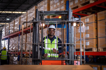 Obraz premium Africa worker industry factory wear safety uniform factory drive forklift truck moving goods boxes to industry production in factory warehouse area is industry manufacturing transportation concept.