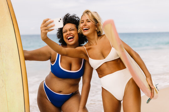 Summer surf fun: Female surfers taking a selfie on the beach