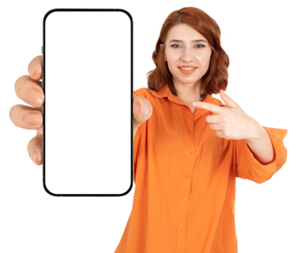 Showing blank smartphone screen and pointing on it. Happy smiling positive red hair caucasian girl in orange shirt recommending great offer on application online shopping advertisement concept idea. - Powered by Adobe