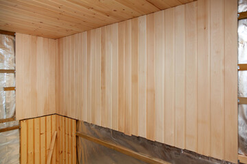 Interior of a new sauna under construction. Wooden walls and ceiling