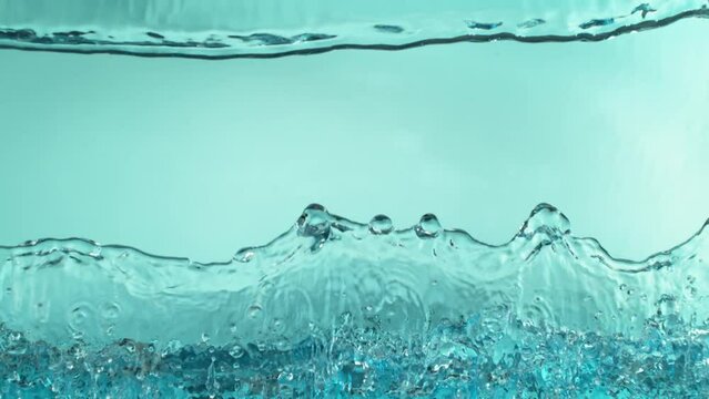 Super slow motion of water wave on light blue background. Filmed on High Speed Cinematic Camera at 1000 FPS