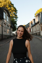 Frontal portrait of smiling young woman walking down the street in Helsinki, Finland