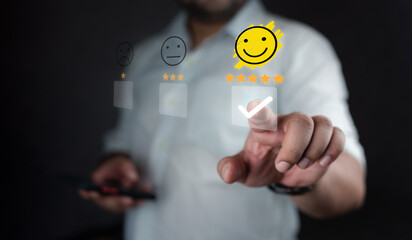 Man touching the virtual screen on the happy face icon and five stars to give satisfaction in...